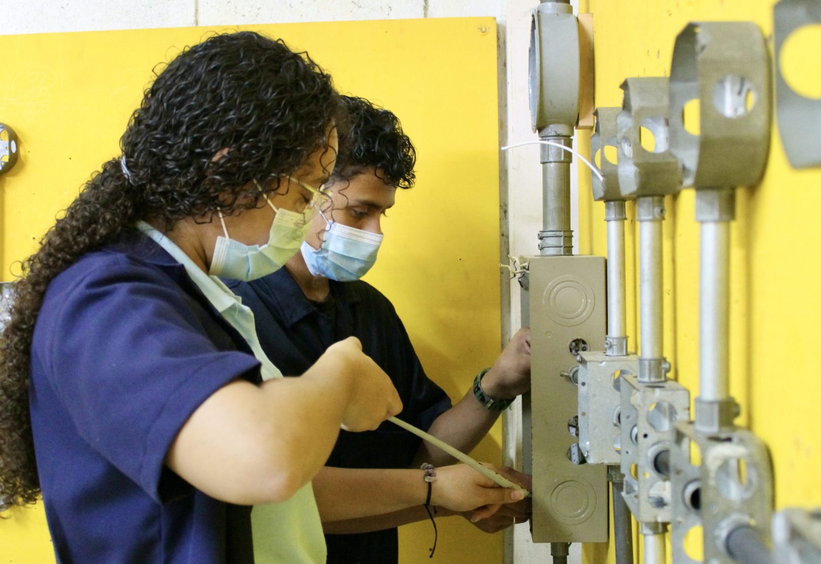 Two students in high school electrical shop.