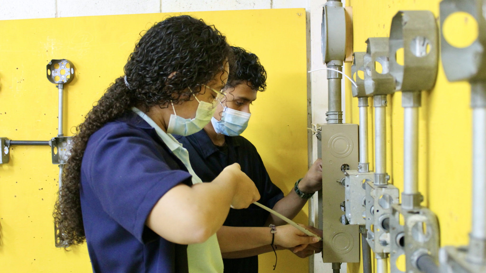 Two students in high school electrical shop.